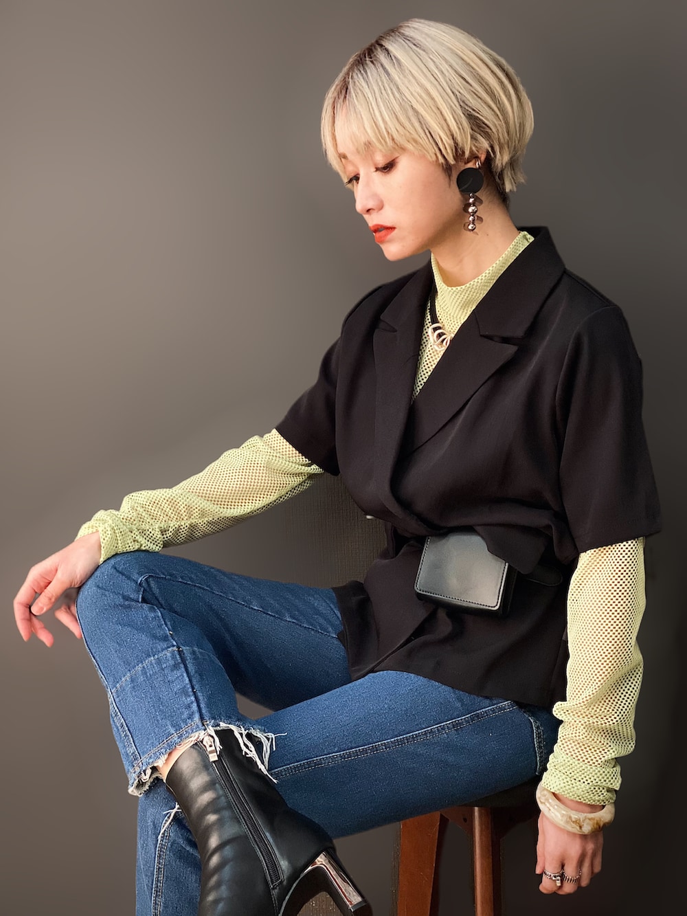 グリーン系のTシャツ/カットソー、ブラック系のテーラードジャケット、ブルー系のデニムパンツを着用したレディースの冬コーディネートの2枚目の写真