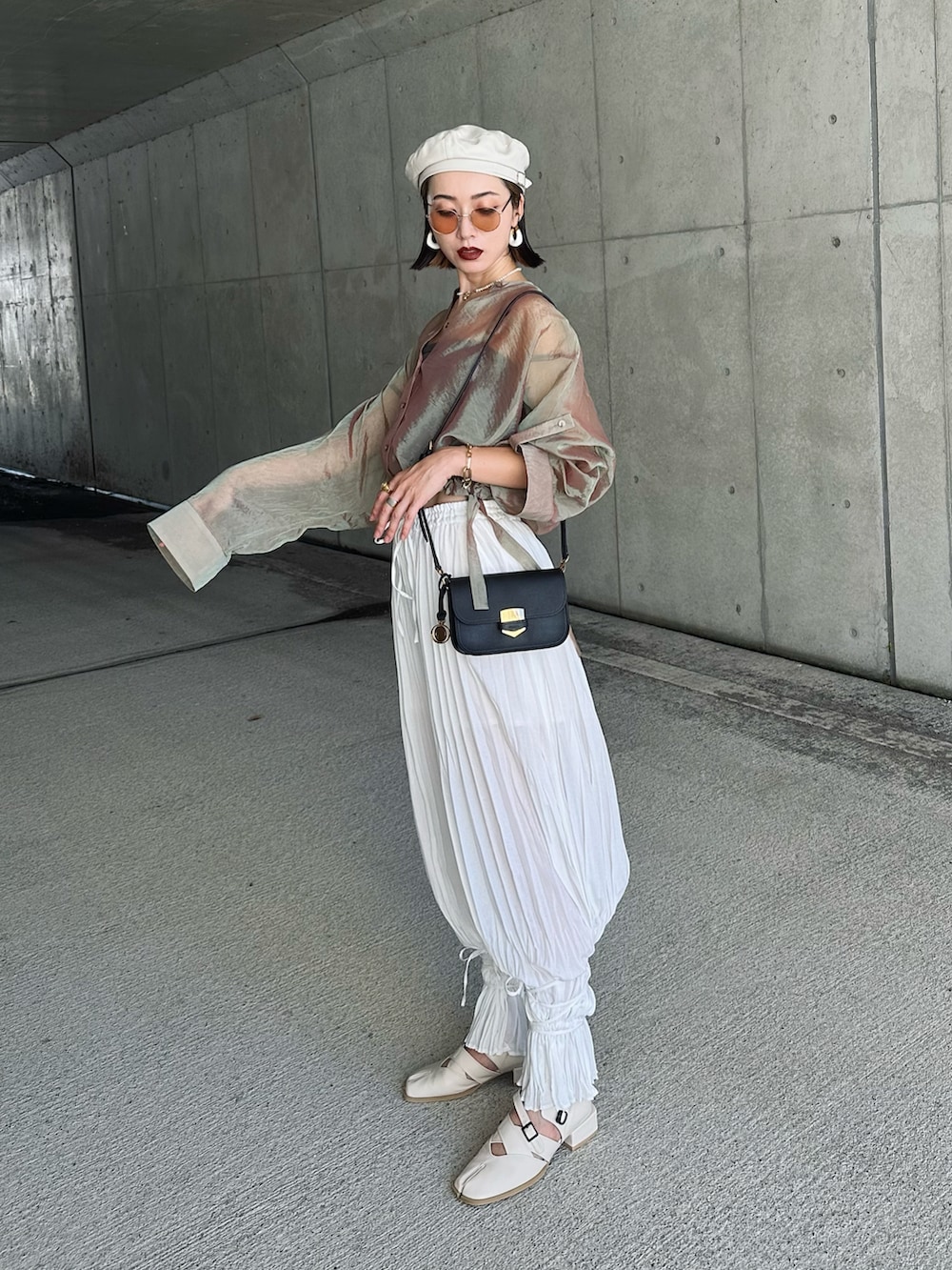 ベージュ系のシャツ/ブラウス、ブラック系のメッセンジャーバッグ、ホワイト系のサンダルを着用したレディースの秋コーディネートの3枚目の写真