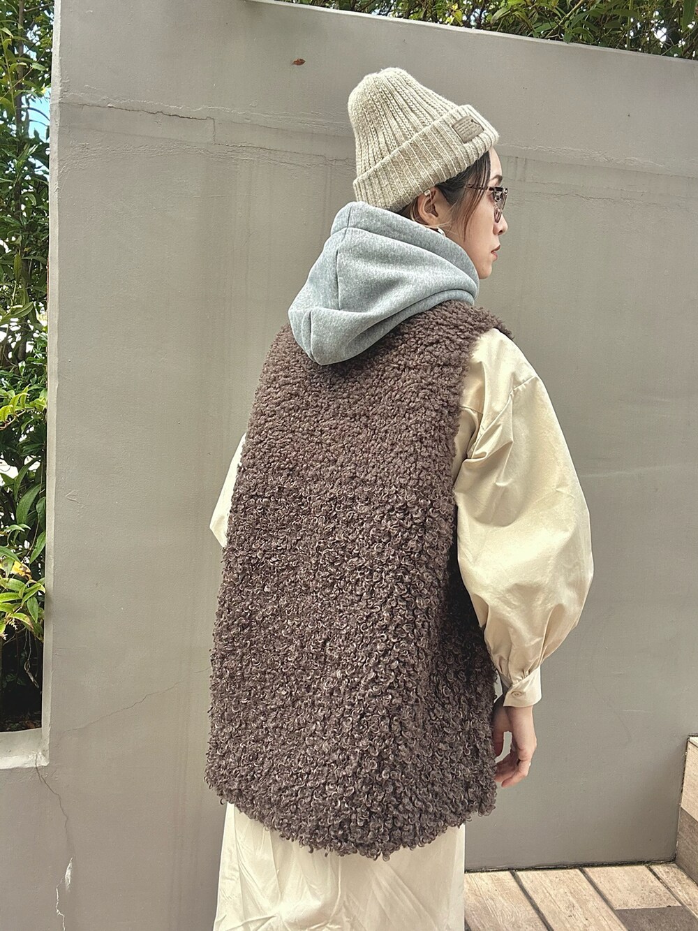 ブラウン系のベスト、ベージュ系のシャツワンピース、レッド系のスニーカーを着用したレディースの秋コーディネートの4枚目の写真