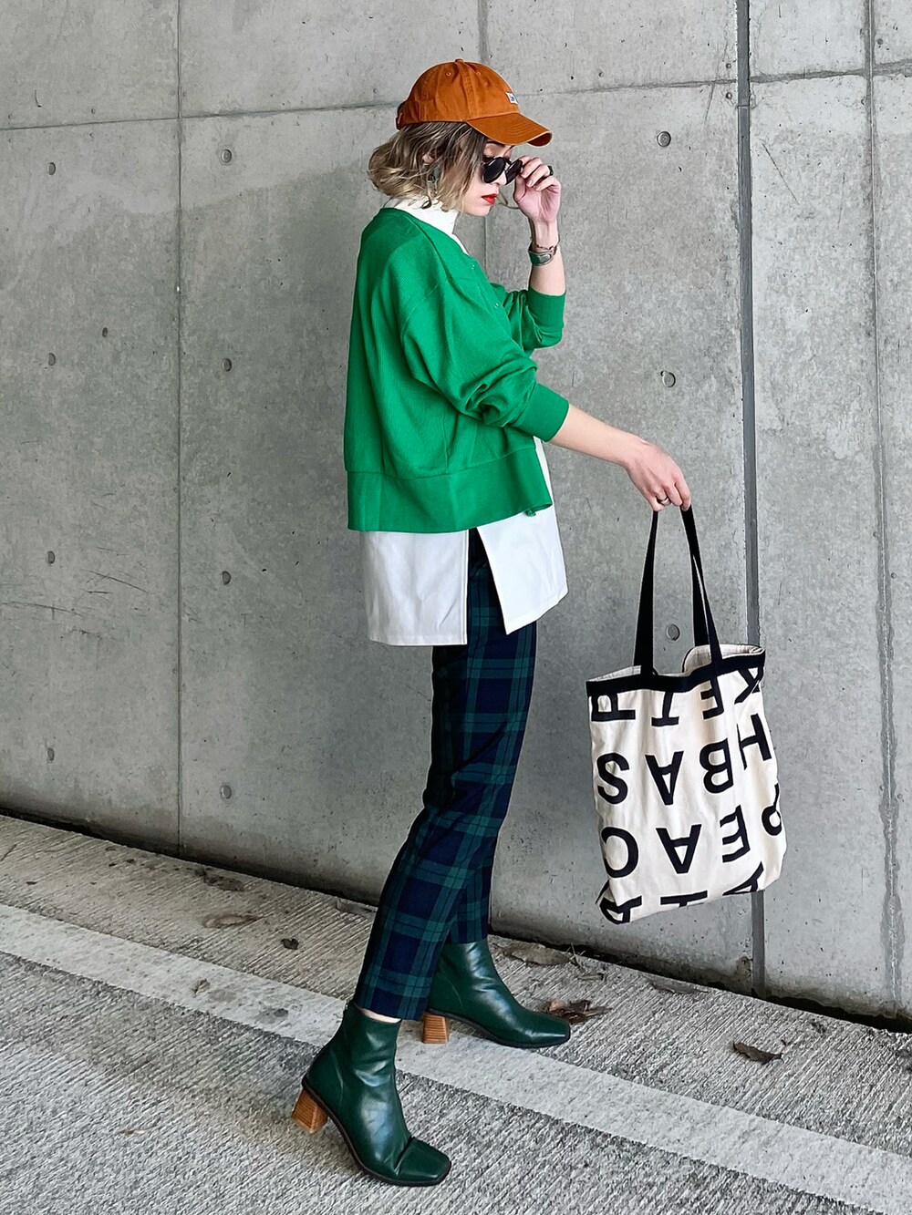 グリーン系のカーディガン/ボレロ、ブラック系のトップス、ブラック系のTシャツ/カットソーを着用したレディースの春コーディネートの5枚目の写真