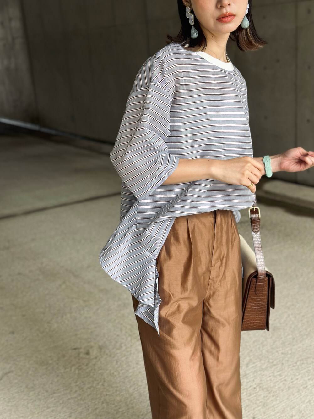 ブルー系のTシャツ/カットソー、ブラウン系のその他パンツ、ブラウン系のメッセンジャーバッグを着用したレディースの夏コーディネートの2枚目の写真