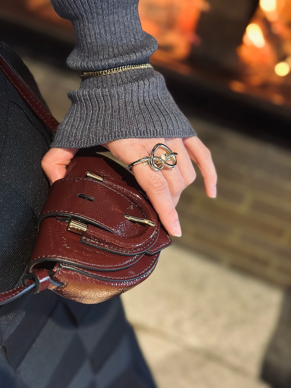 グレー系のニット/セーター、ブラック系のハンドバッグ、ブラック系のスカートを着用したレディースの冬コーディネートの3枚目の写真