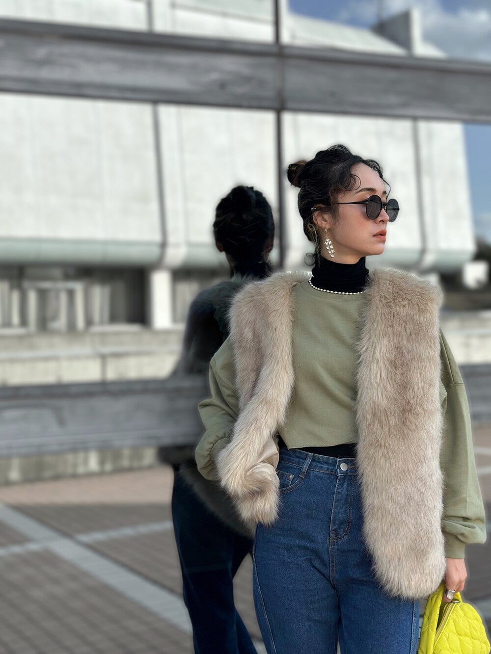 グリーン系のニット/セーター、ブルー系のデニムパンツ、ブラック系のブーツを着用したレディースの冬コーディネートの4枚目の写真