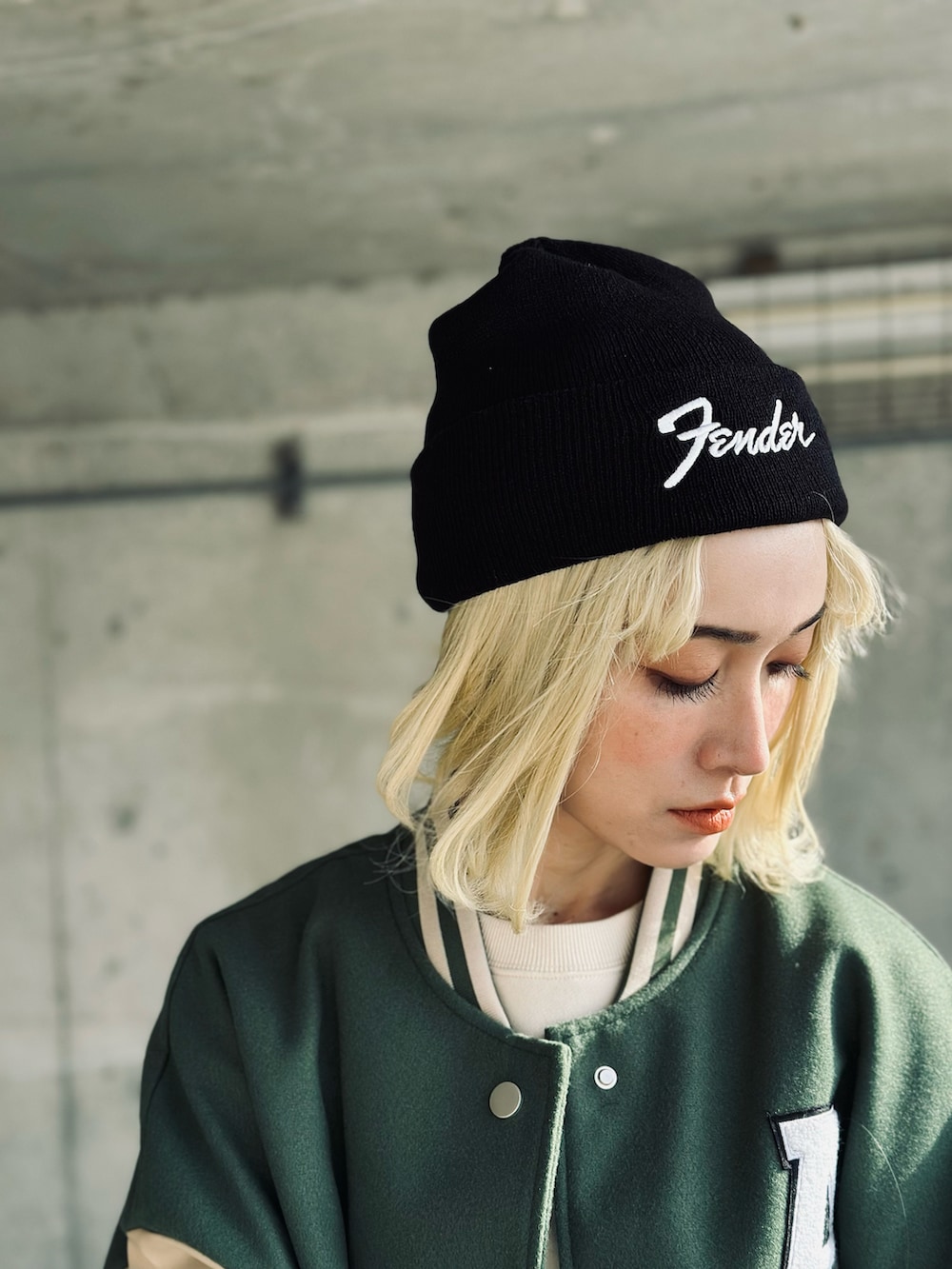 ホワイト系のスウェット、グリーン系のスタジャン、ホワイト系のハンドバッグを着用したレディースの冬コーディネートの3枚目の写真