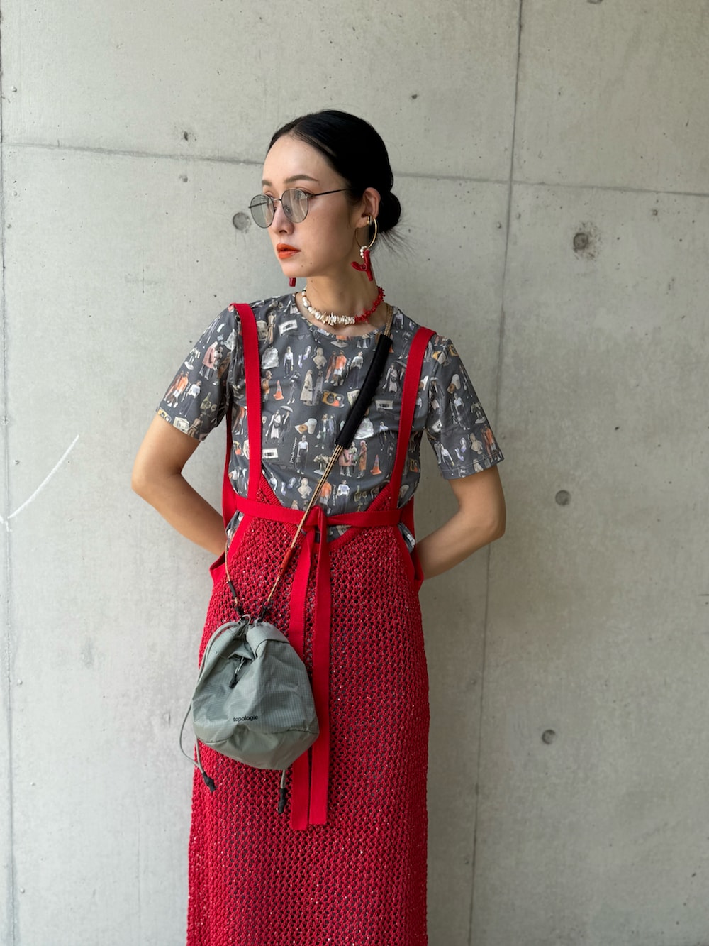 レッド系のニット/セーター、グレー系のショルダーバッグ、グレー系のTシャツ/カットソーを着用したレディースの夏コーディネートの2枚目の写真