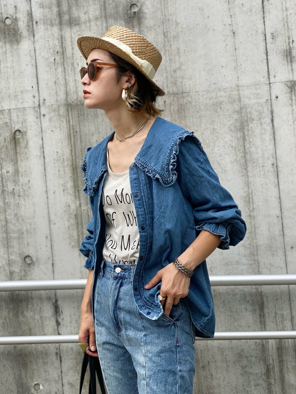 ブラック系のトートバッグ、ブルー系のシャツ/ブラウス、ホワイト系のブーツを着用したレディースの夏コーディネートの2枚目の写真