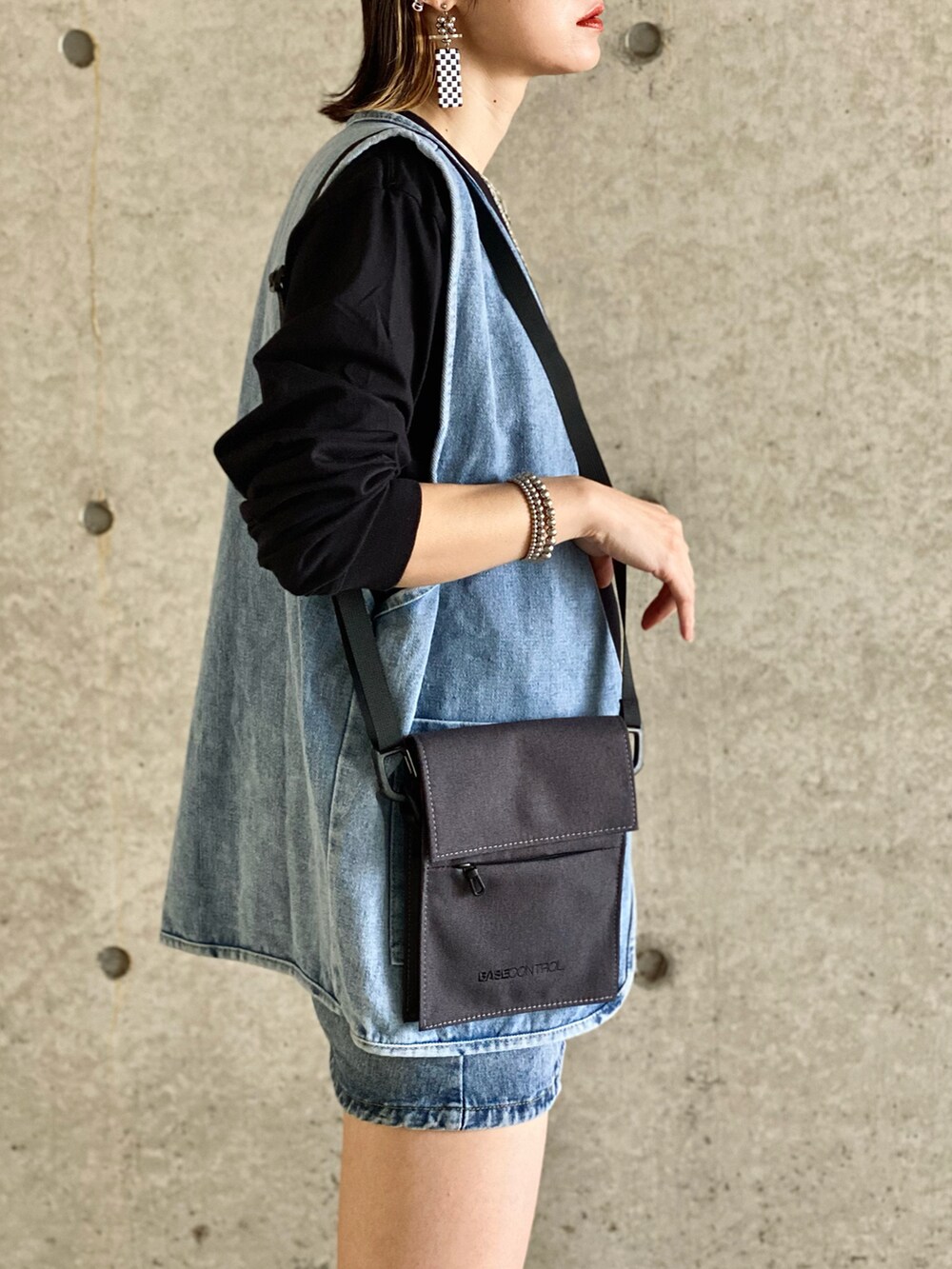 ホワイト系のTシャツ/カットソー、グレー系のショルダーバッグ、ブルー系のデニムスカートを着用したレディースの春コーディネートの3枚目の写真