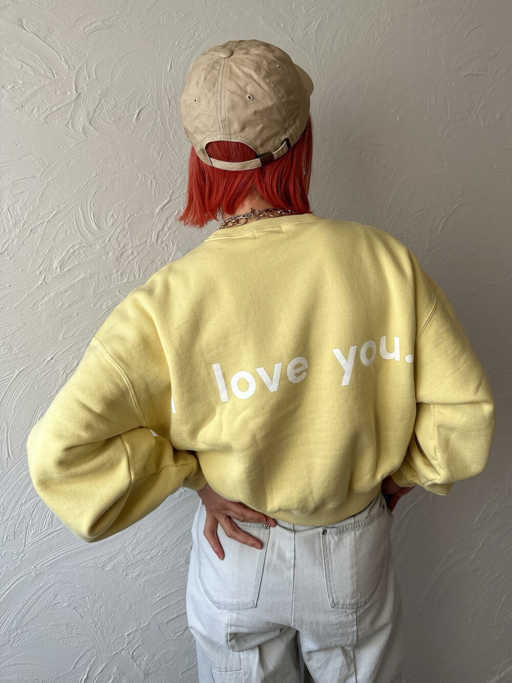 イエロー系のスウェット、ブルー系のデニムパンツ、ベージュ系のスニーカーを着用したレディースの春コーディネートの2枚目の写真