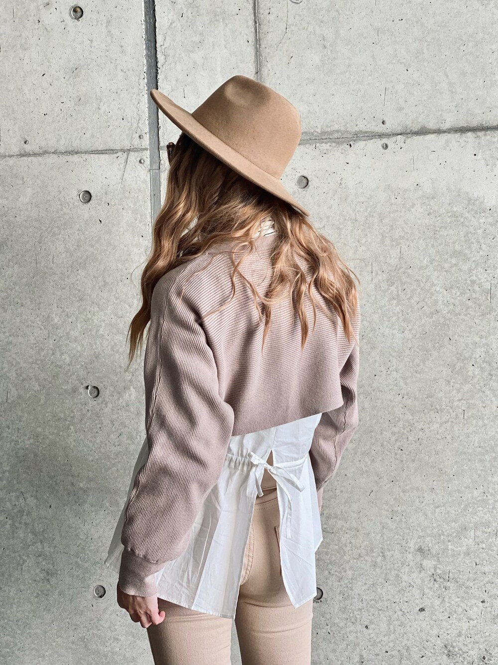 ブラウン系のニット/セーター、その他のショルダーバッグ、ホワイト系のブルゾンを着用したレディースの冬コーディネートの5枚目の写真