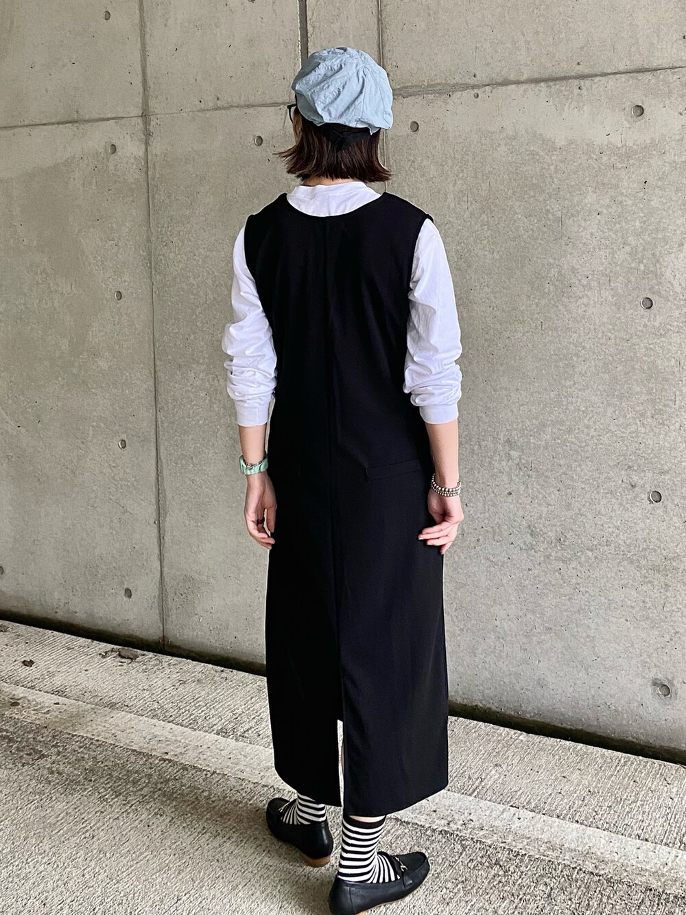 ブラック系のローファー、ブラック系のワンピース、ホワイト系のTシャツ/カットソーを着用したレディースの春コーディネートの5枚目の写真
