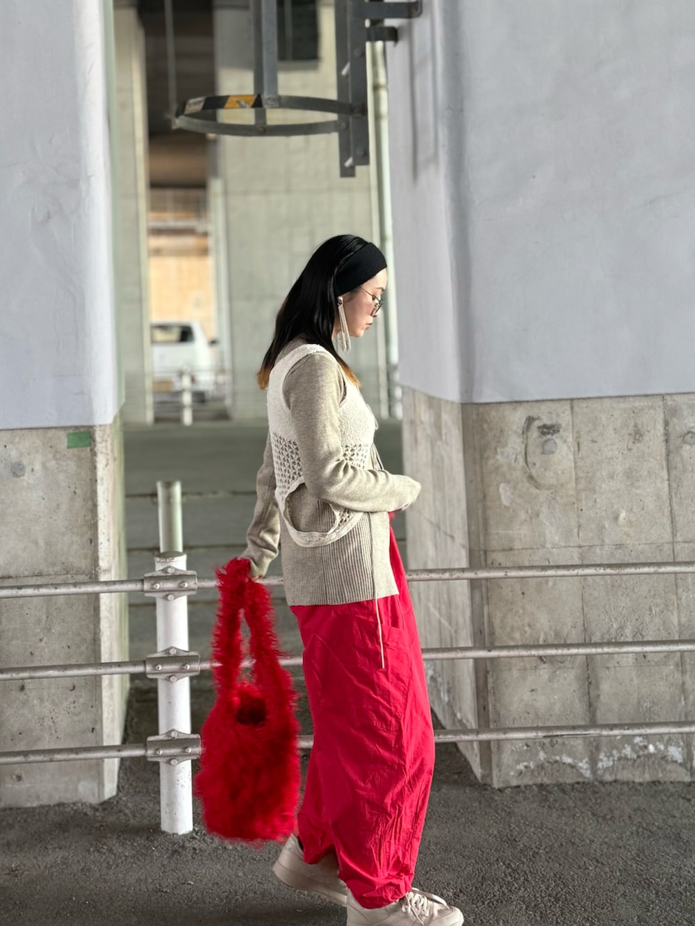 ホワイト系のニット/セーター、ホワイト系のタンクトップ、レッド系のトートバッグを着用したレディースの冬コーディネートの5枚目の写真
