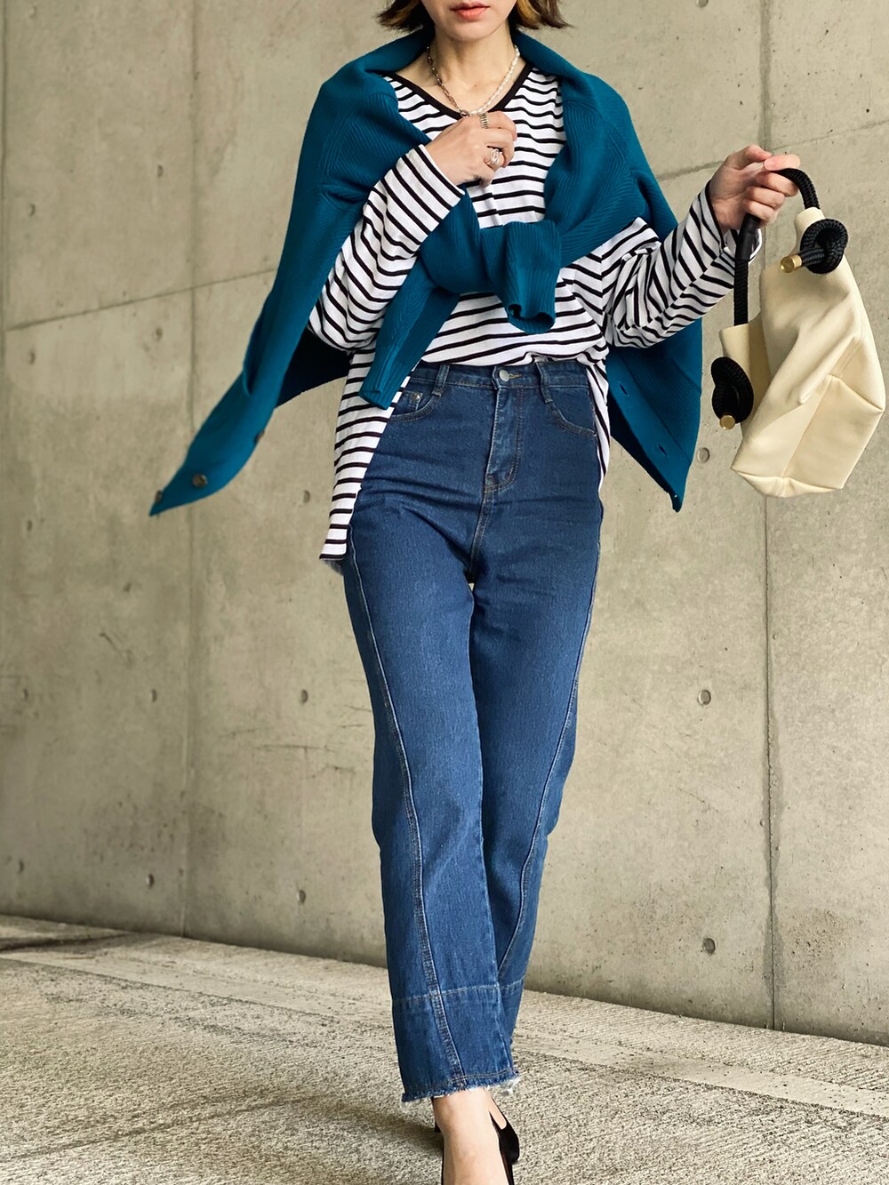 ブルー系のカーディガン/ボレロ、ブルー系のデニムパンツ、ホワイト系のTシャツ/カットソーを着用したレディースの冬コーディネートの4枚目の写真