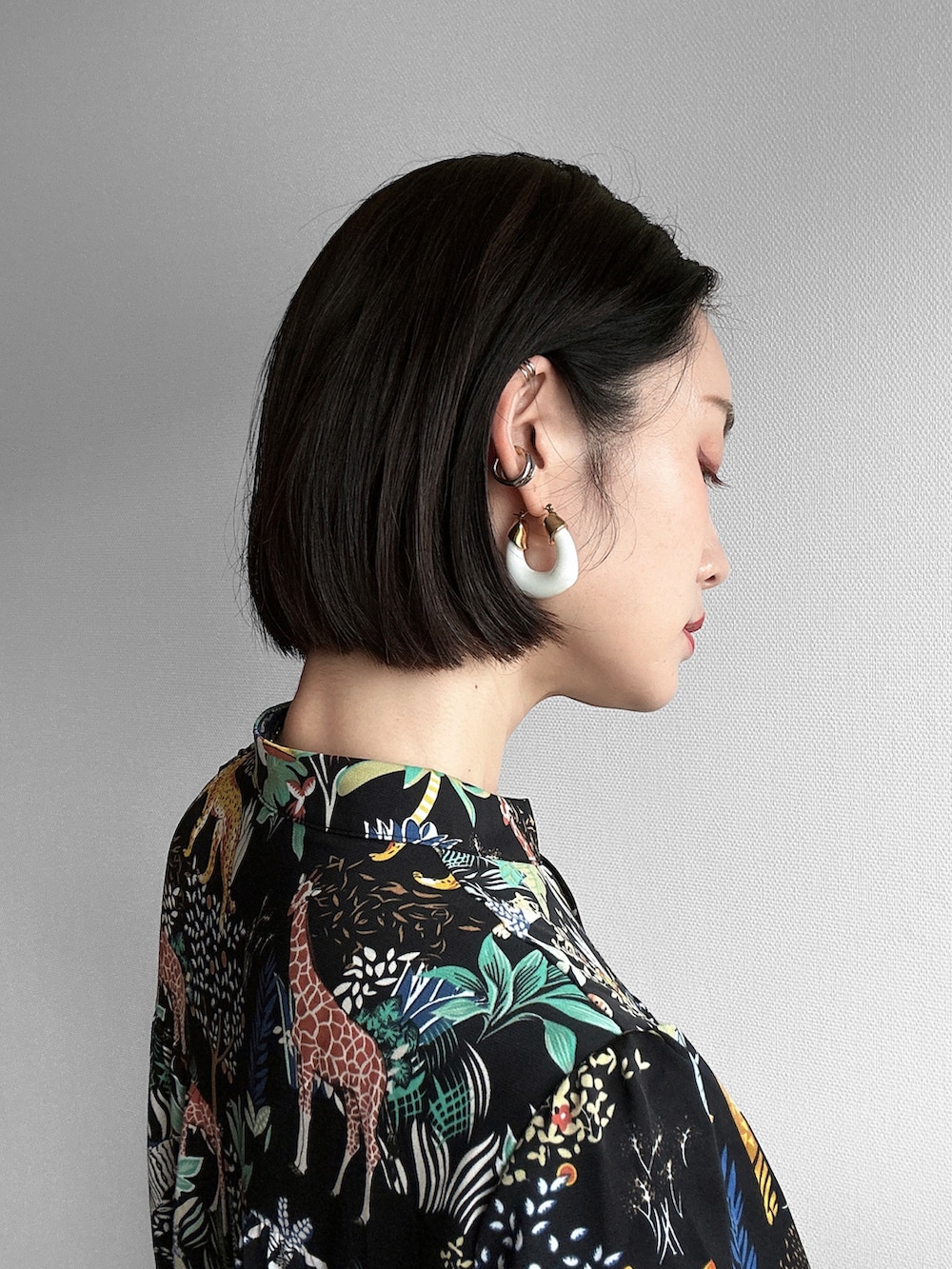 ブラック系のワンピース、シルバー系のサンダル、オレンジ系のトートバッグを着用したレディースの春コーディネートの4枚目の写真