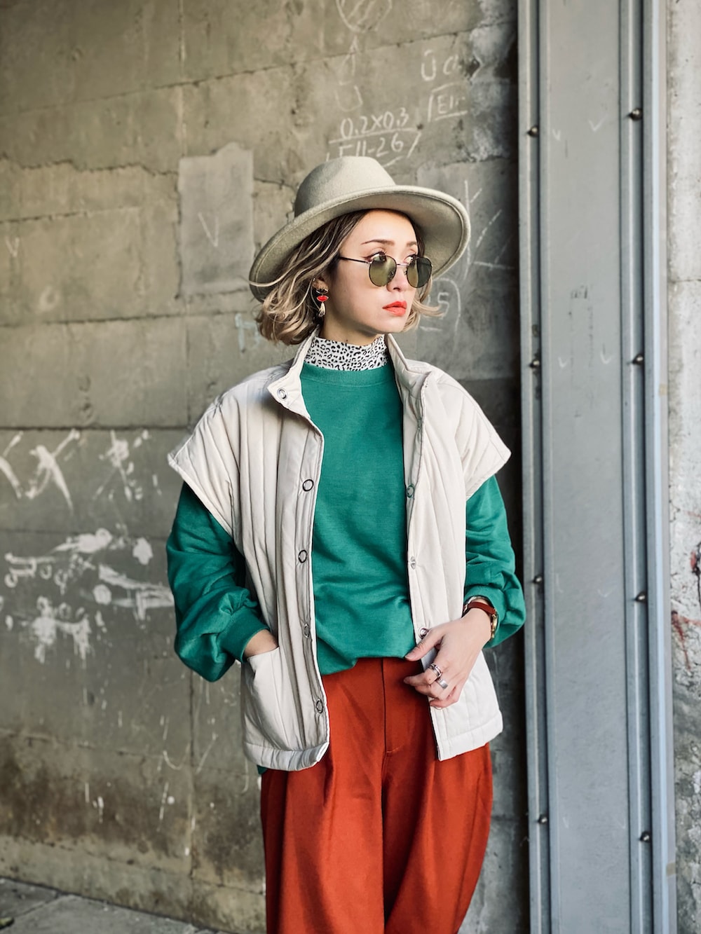 グリーン系のスウェット、ホワイト系のダウンベスト、ベージュ系のボストンバッグを着用したレディースの冬コーディネートの4枚目の写真