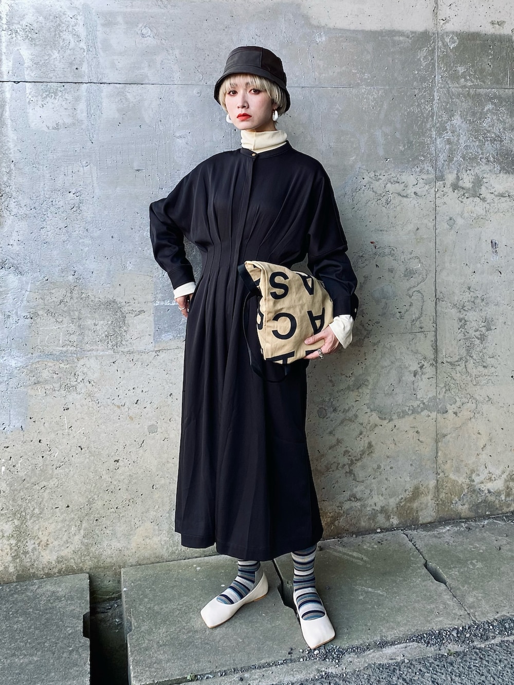 ホワイト系のパンプス、ブラック系のワンピース、ベージュ系のトートバッグを着用したレディースの秋コーディネートの5枚目の写真