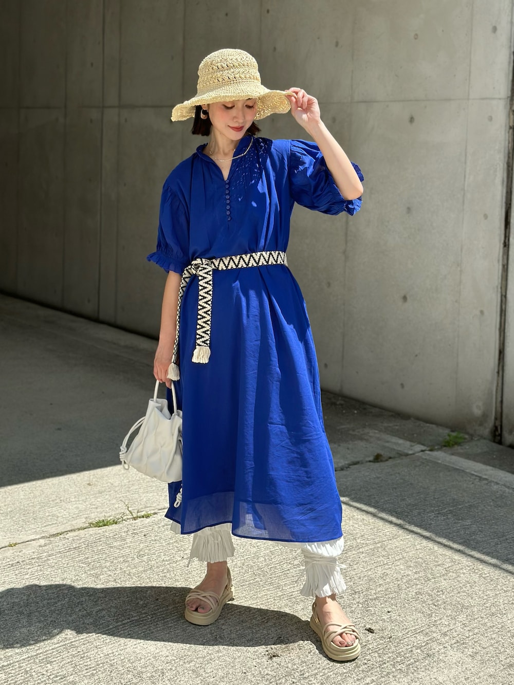 ブルー系のワンピース、ブラック系のトートバッグ、ブラック系のサンダルを着用したレディースの春コーディネートの3枚目の写真