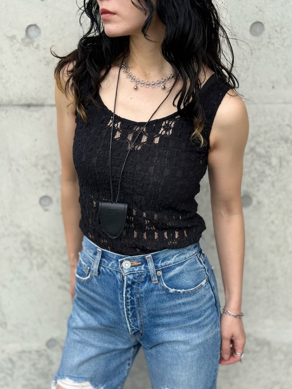 ブラック系のタンクトップ、ブルー系のサンダル、グレー系のトレンチコートを着用したレディースの春コーディネートの3枚目の写真