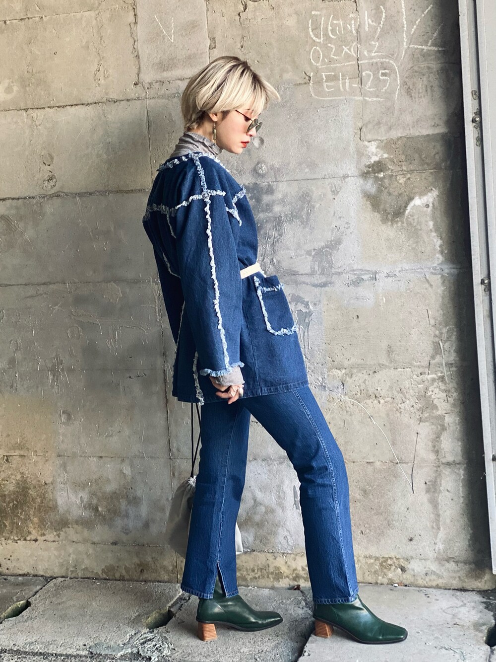 グレー系のTシャツ/カットソー、グレー系のトートバッグ、ブルー系のデニムジャケットを着用したレディースの冬コーディネートの4枚目の写真