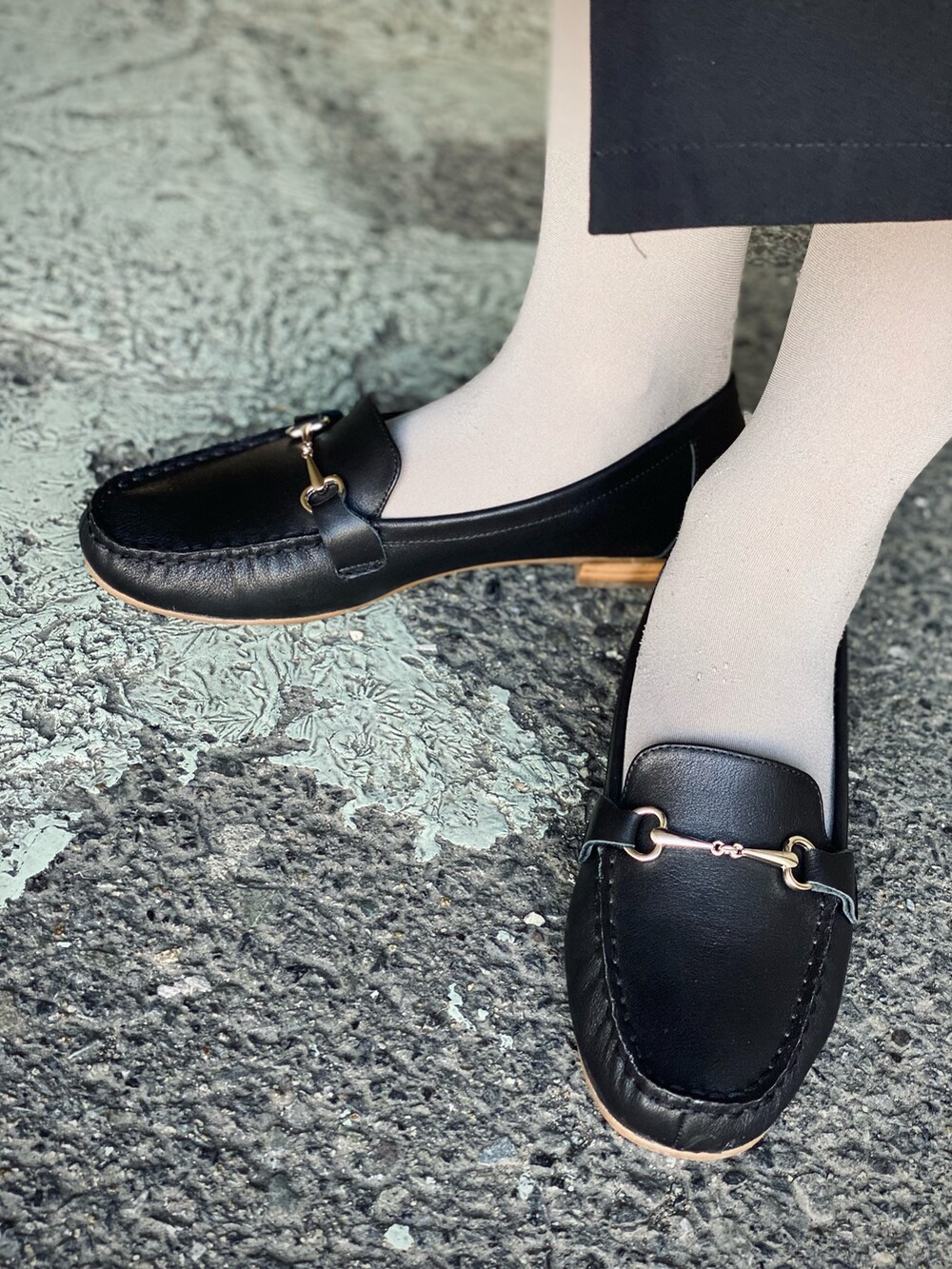 ブラック系のワンピース、グリーン系のハンドバッグ、ブラック系のローファーを着用したレディースの春コーディネートの5枚目の写真