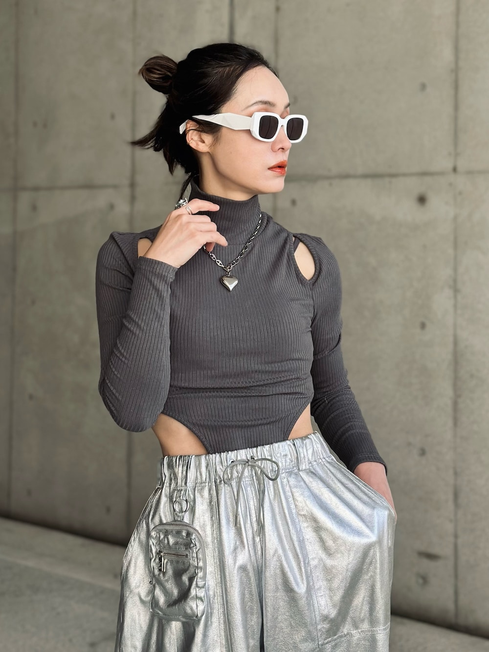 ブラック系のハンドバッグ、シルバー系のその他パンツ、ブルー系のチェスターコートを着用したレディースの冬コーディネートの2枚目の写真