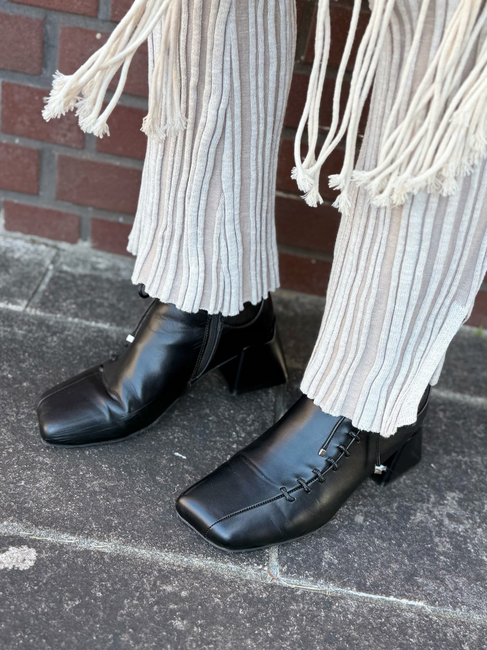 ブラック系のブーツ、グレー系のテーラードジャケット、ブラウン系のショルダーバッグを着用したレディースの冬コーディネートの4枚目の写真