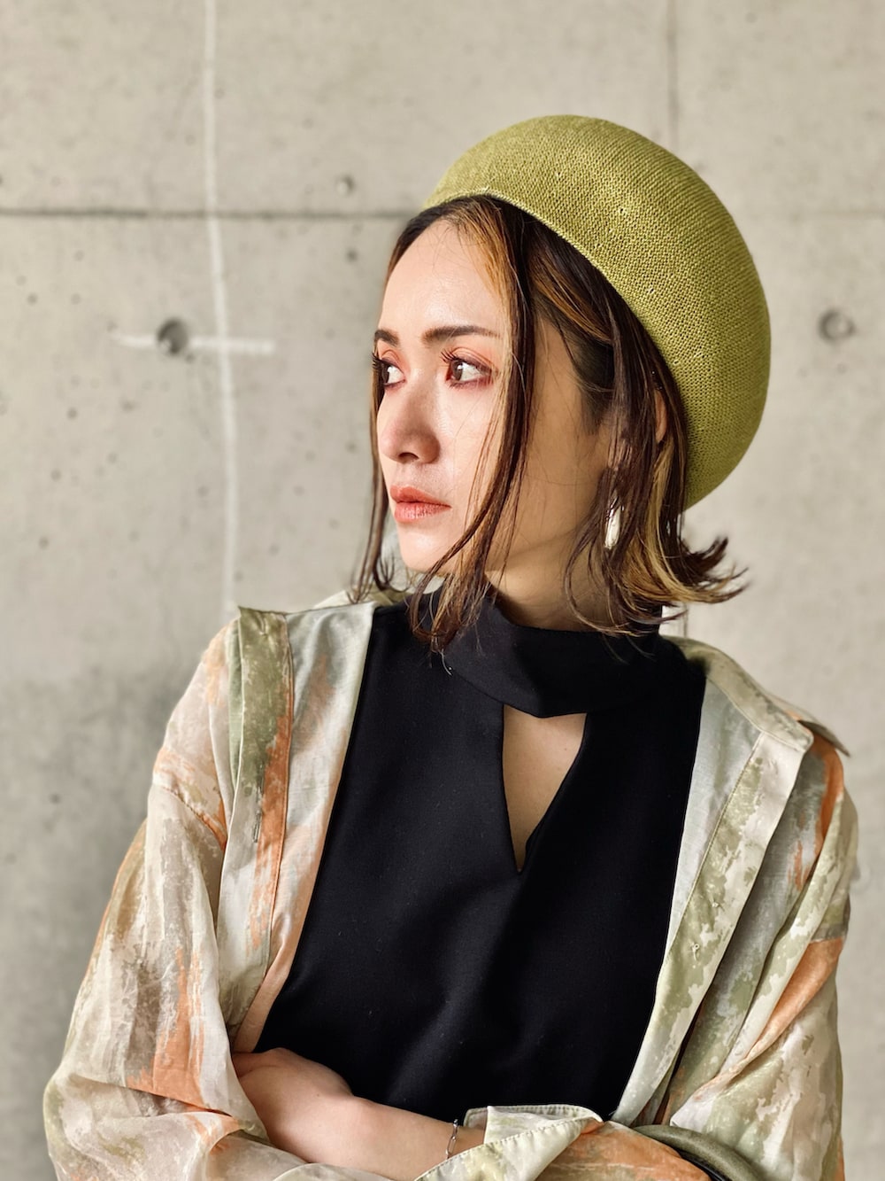 ブラック系のTシャツ/カットソー、オレンジ系のスラックス、グリーン系のハンドバッグを着用したレディースの春コーディネートの4枚目の写真