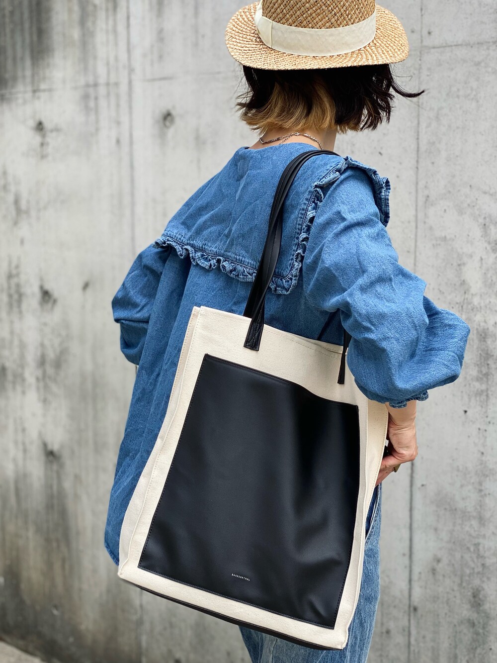 ブラック系のトートバッグ、ブルー系のシャツ/ブラウス、ホワイト系のブーツを着用したレディースの夏コーディネートの3枚目の写真