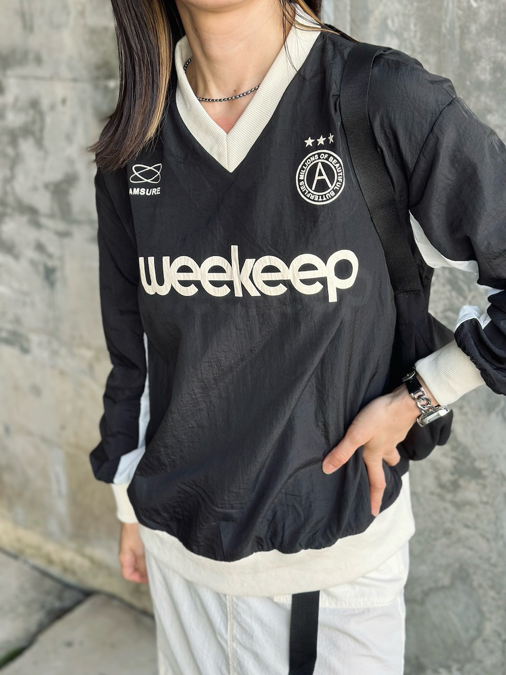 ホワイト系のスカート、ベージュ系のスニーカー、ブラック系のTシャツ/カットソーを着用したレディースの夏コーディネートの2枚目の写真