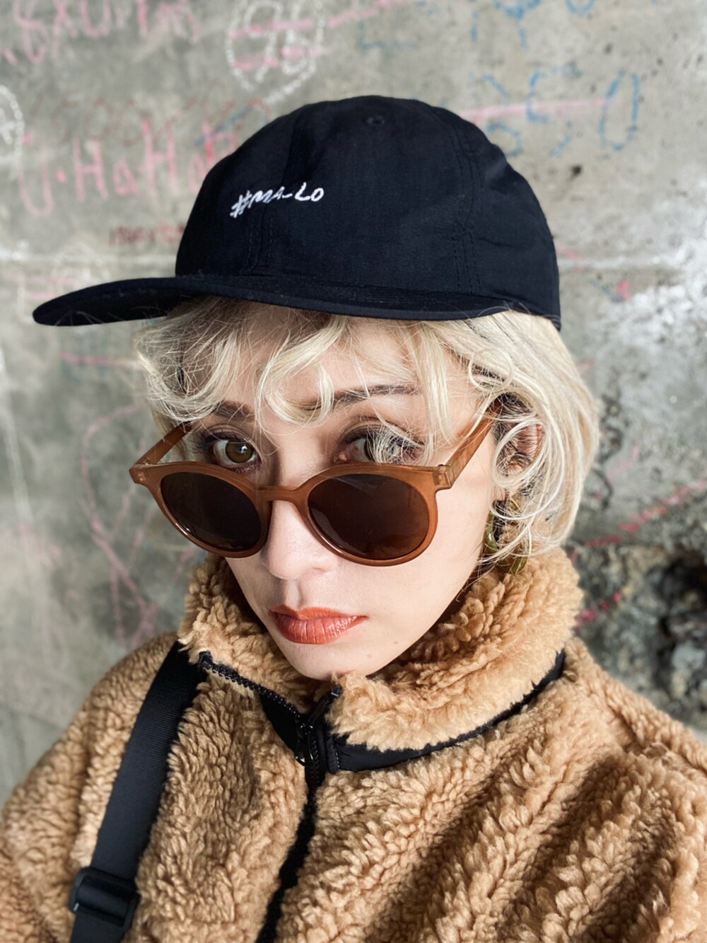 ベージュ系のブルゾン、ブラック系のショルダーバッグ、ブラック系のデニムパンツを着用したレディースの冬コーディネートの4枚目の写真