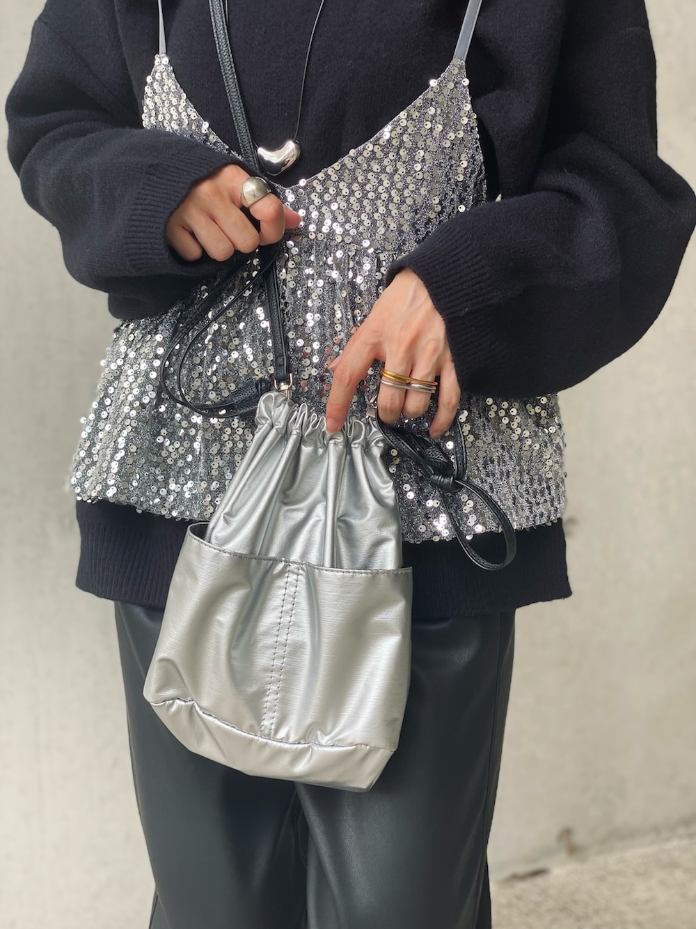 ブラック系のニット/セーター、ブラック系のその他パンツ、シルバー系のキャミソールを着用したレディースの秋コーディネートの5枚目の写真