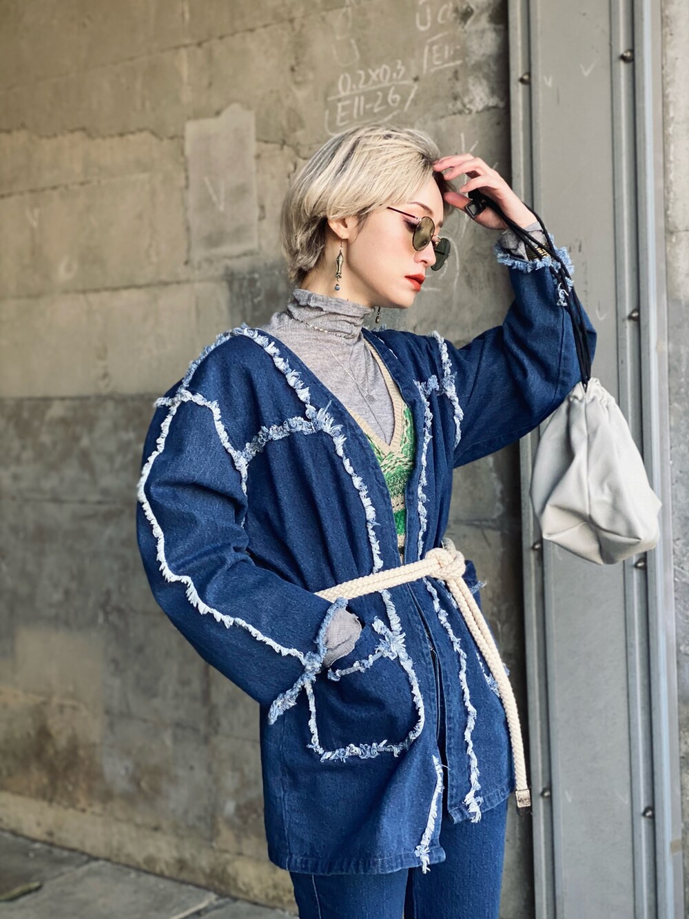 グレー系のTシャツ/カットソー、グレー系のトートバッグ、ブルー系のデニムジャケットを着用したレディースの冬コーディネートの3枚目の写真