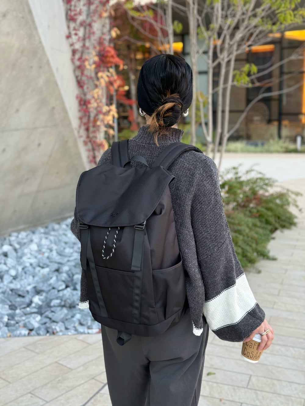 グレー系のスウェットパンツ、ブラック系のローファー、ブラック系のバックパック/リュックを着用したレディースの春コーディネートの2枚目の写真