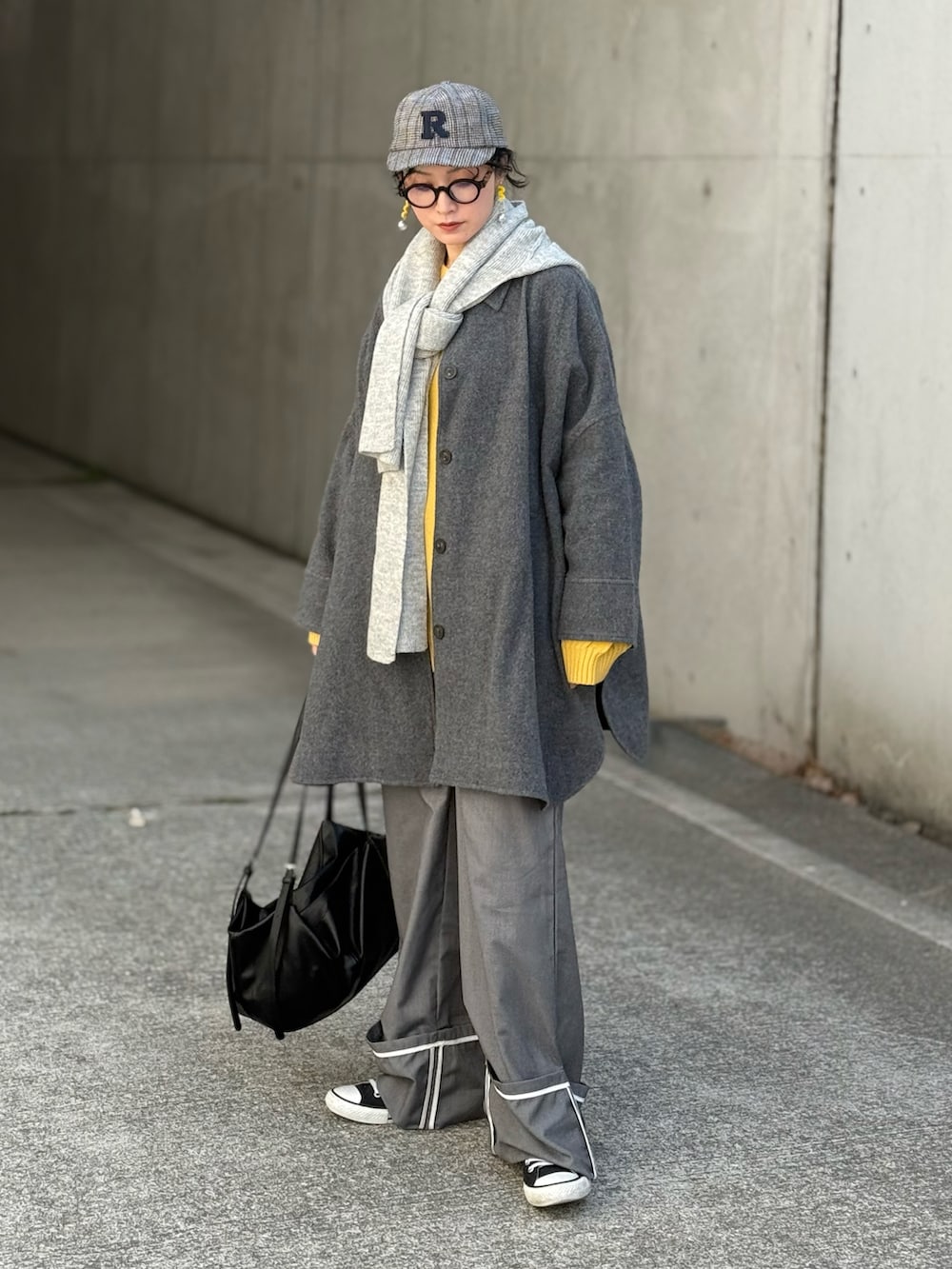 イエロー系のニット/セーター、グレー系のその他アウター、グレー系のスラックスを着用したレディースの春コーディネートの4枚目の写真