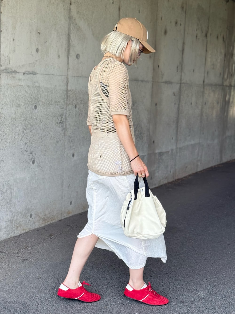 ベージュ系のタンクトップ、ホワイト系のショルダーバッグ、ベージュ系のTシャツ/カットソーを着用したレディースの夏コーディネートの3枚目の写真