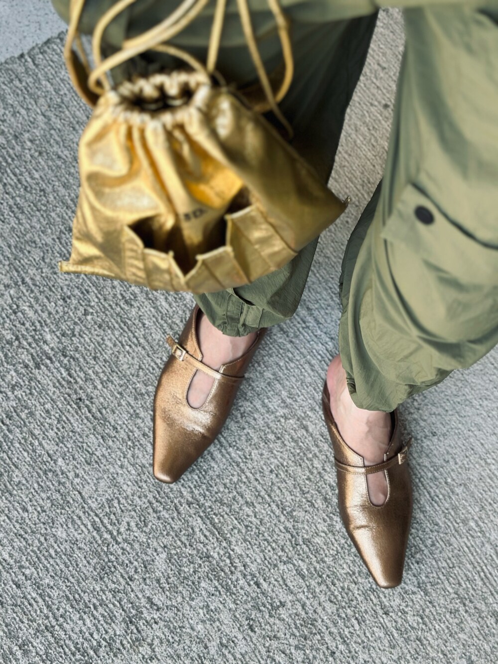 グリーン系のカーゴパンツ、ゴールド系のパンプス、ゴールド系のショルダーバッグを着用したレディースの夏コーディネートの4枚目の写真