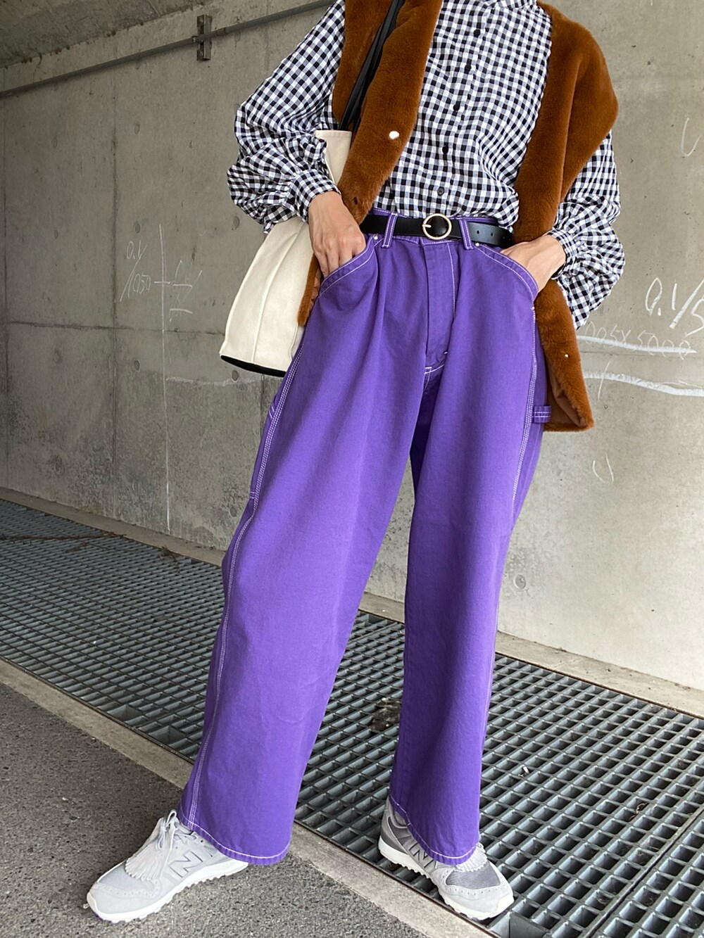 ブラック系のシャツ/ブラウス、イエロー系のベスト、パープル系のデニムパンツを着用したレディースの秋コーディネートの4枚目の写真