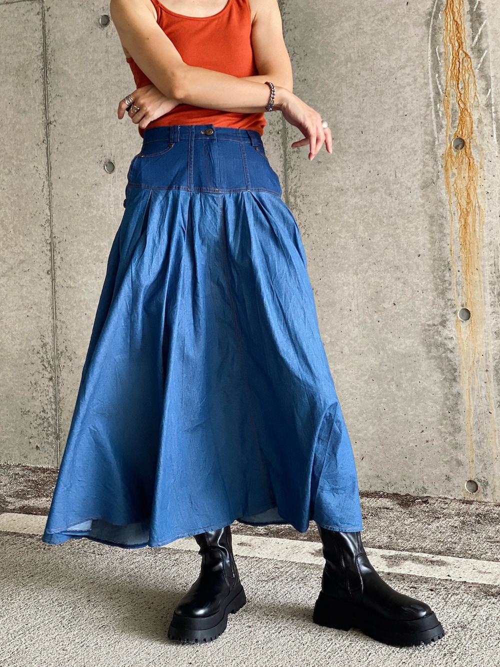 ブラック系のMA-1、ブルー系のデニムスカート、オレンジ系のタンクトップを着用したレディースの秋コーディネートの5枚目の写真