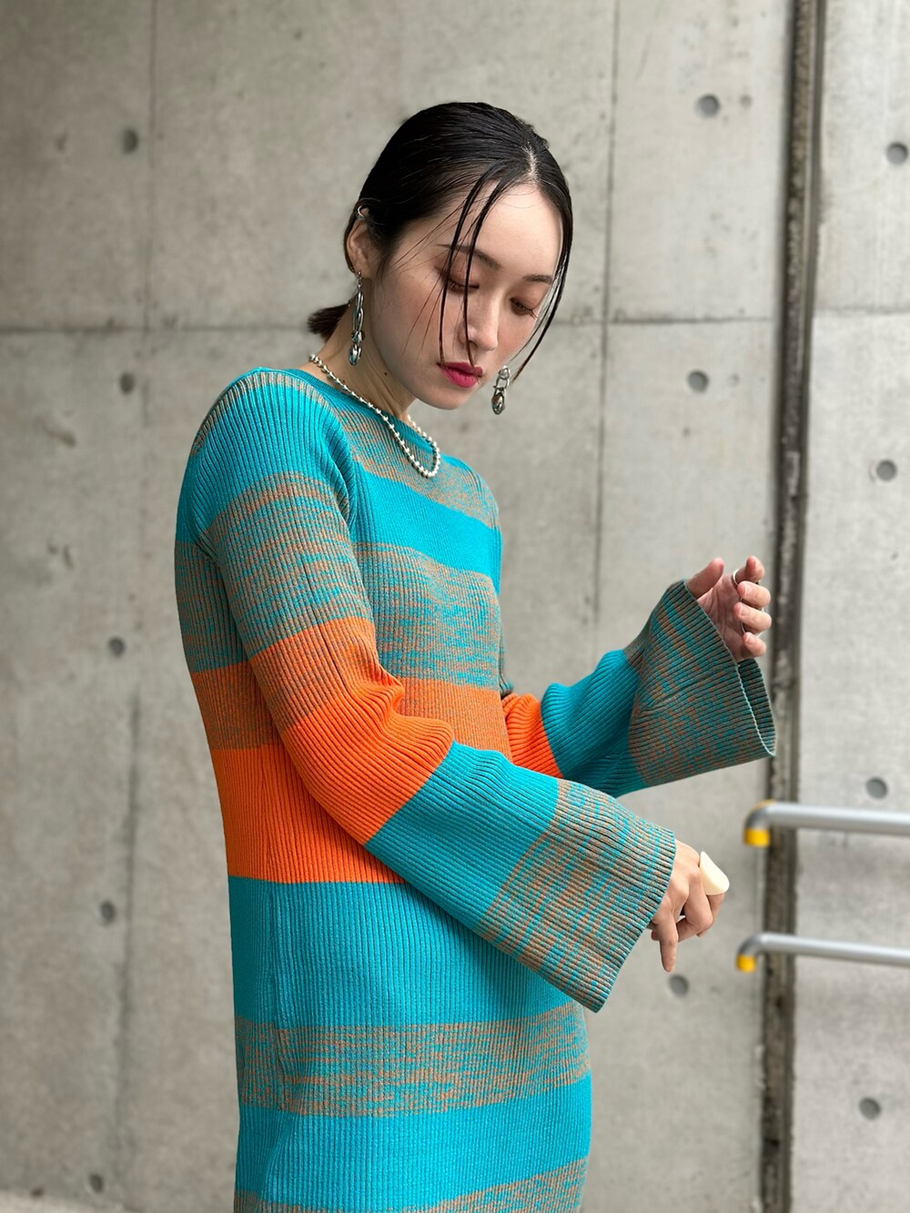 ブルー系のワンピース、ホワイト系のダウンベスト、ベージュ系のブーツを着用したレディースの秋コーディネートの2枚目の写真