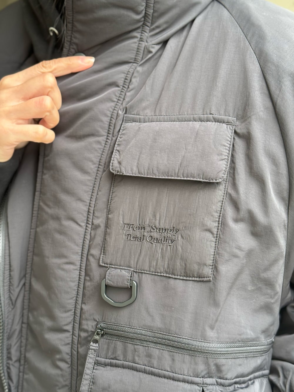 ブラック系のナイロンジャケット、パープル系のスニーカー、ブラック系のその他パンツを着用したレディースの秋コーディネートの3枚目の写真