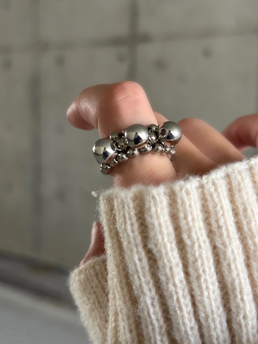 ブラック系のカーディガン/ボレロ、ブラック系のトートバッグ、ブラック系のブーツを着用したレディースの秋コーディネートの5枚目の写真