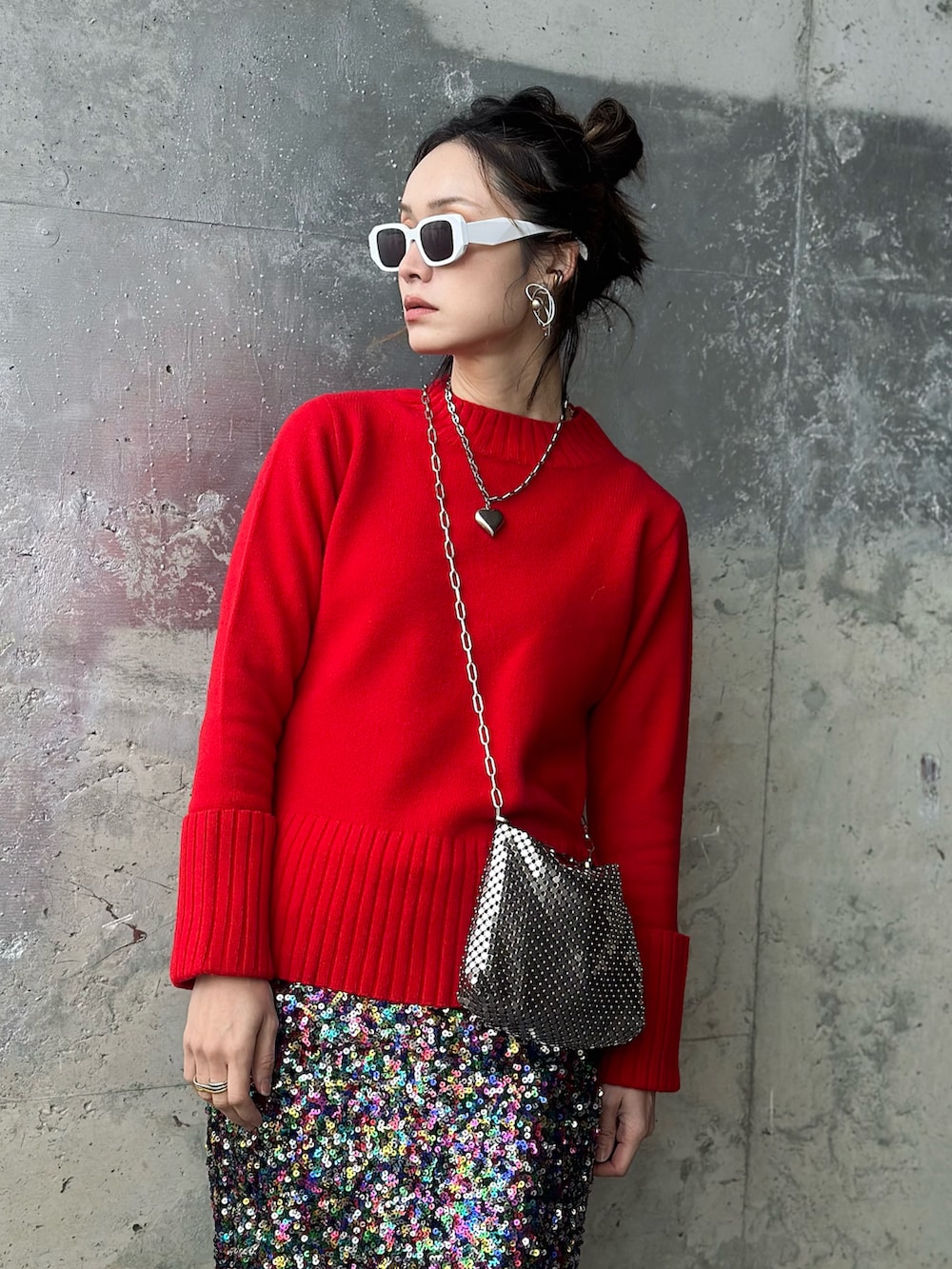 レッド系のニット/セーター、レッド系のブーツ、その他のスカートを着用したレディースの冬コーディネートの2枚目の写真