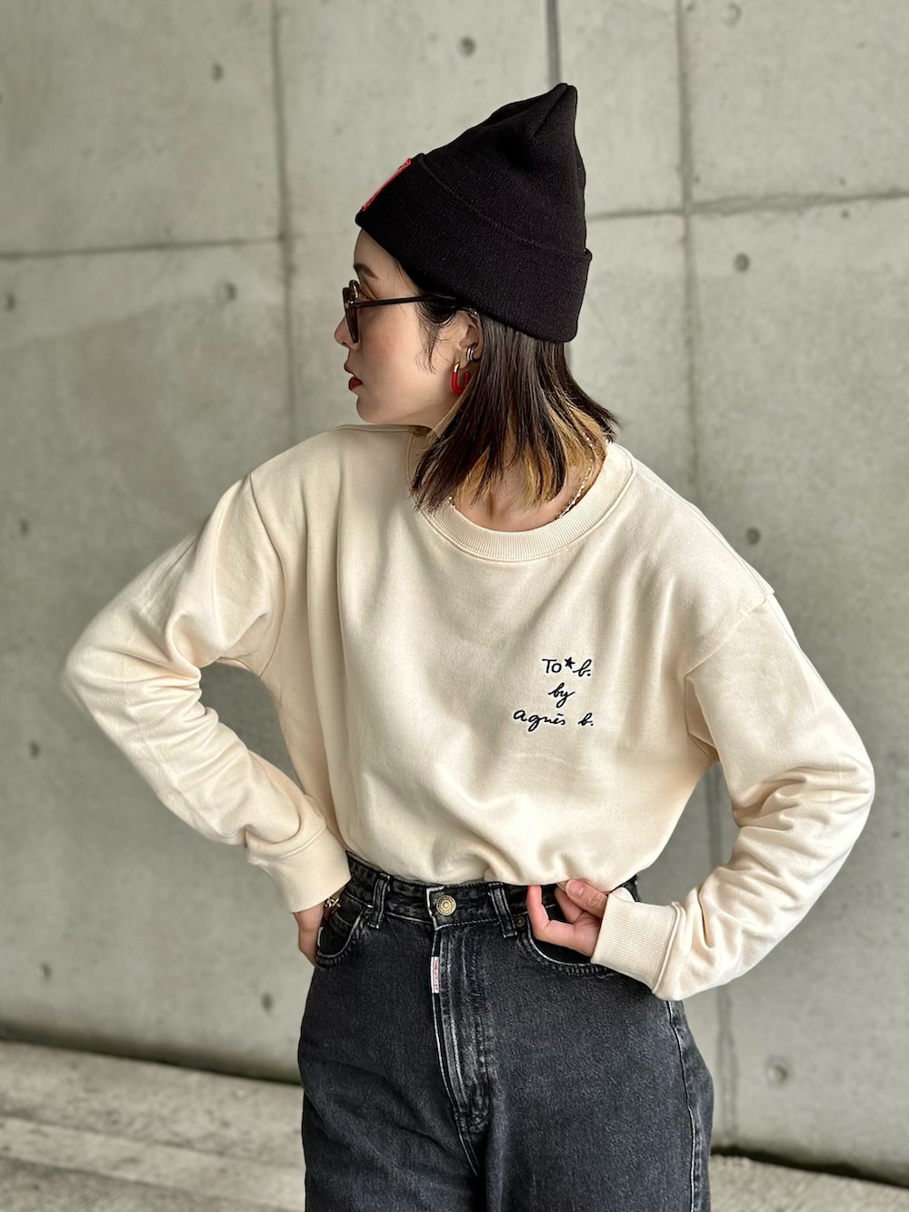 ホワイト系のスウェット、ブラウン系のチェスターコート、ブラック系のスニーカーを着用したレディースの秋コーディネートの2枚目の写真