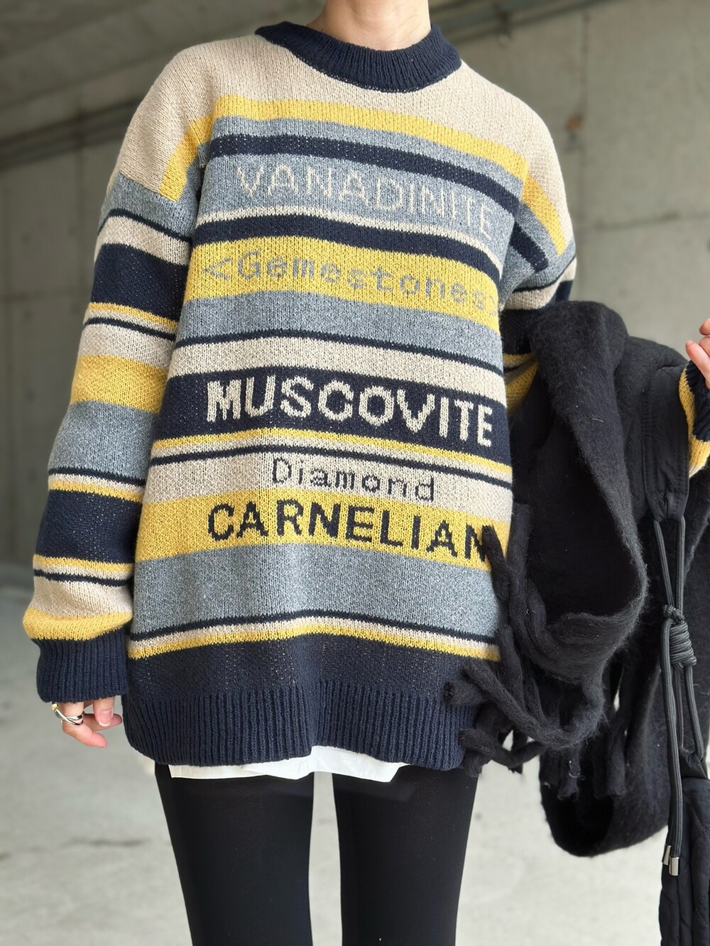 ブルー系のニット/セーター、ブラック系のショルダーバッグ、ブラック系のスニーカーを着用したレディースの冬コーディネートの3枚目の写真