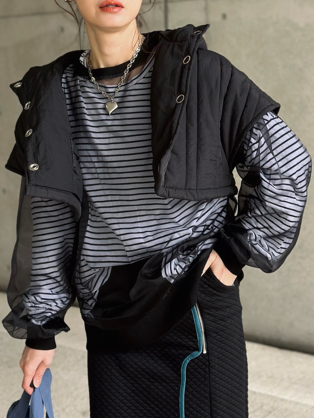 ブラック系のスカート、ブラック系のTシャツ/カットソー、ホワイト系のTシャツ/カットソーを着用したレディースの冬コーディネートの4枚目の写真