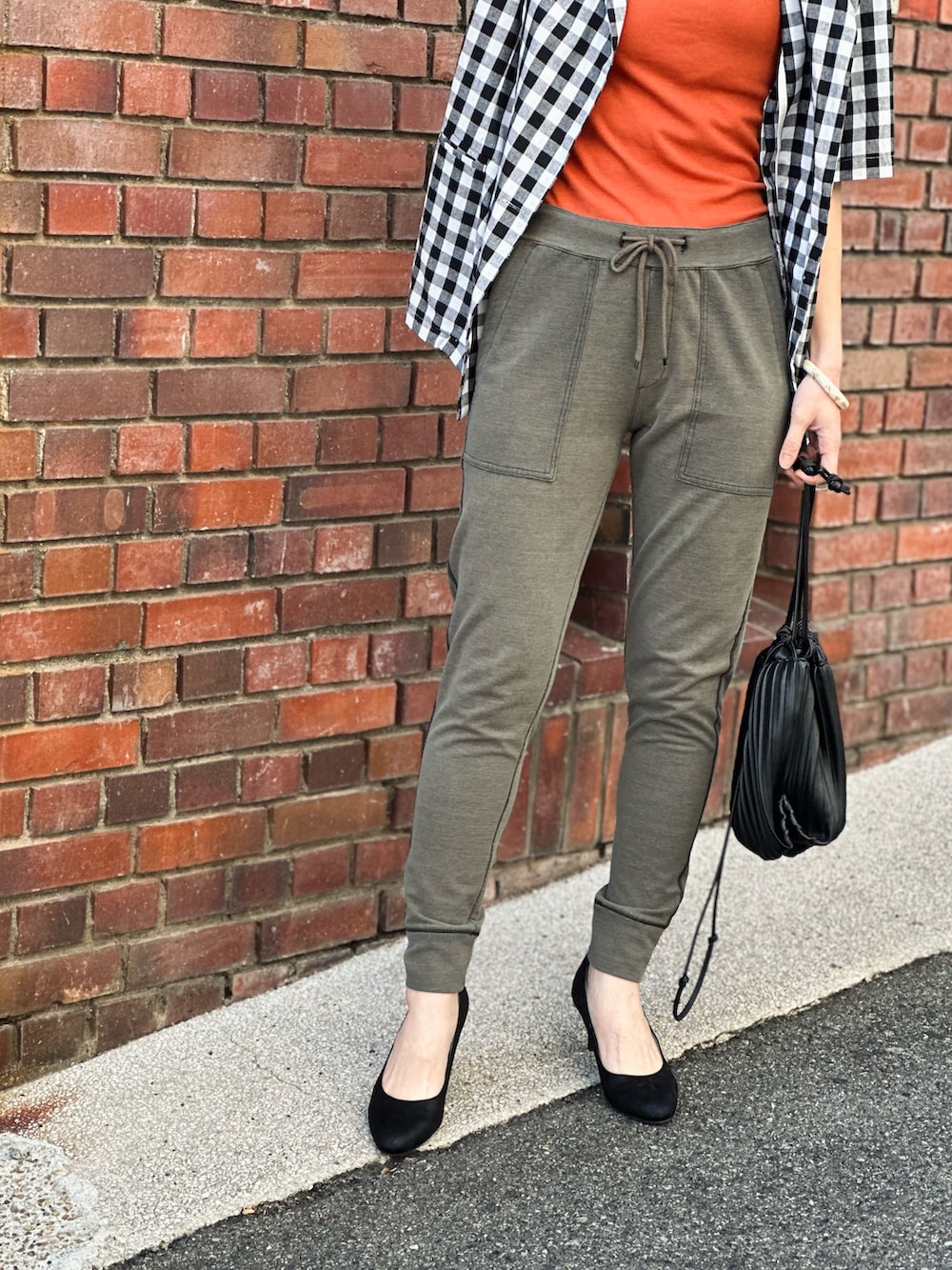 グリーン系のその他パンツ、オレンジ系のタンクトップ、ブラック系のパンプスを着用したレディースの春コーディネートの2枚目の写真