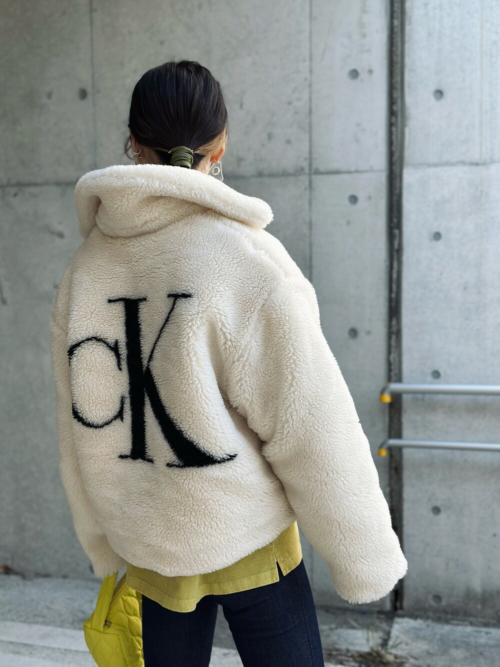 ホワイト系のその他アウター、ブルー系のデニムパンツ、イエロー系のショルダーバッグを着用したレディースの秋コーディネートの2枚目の写真