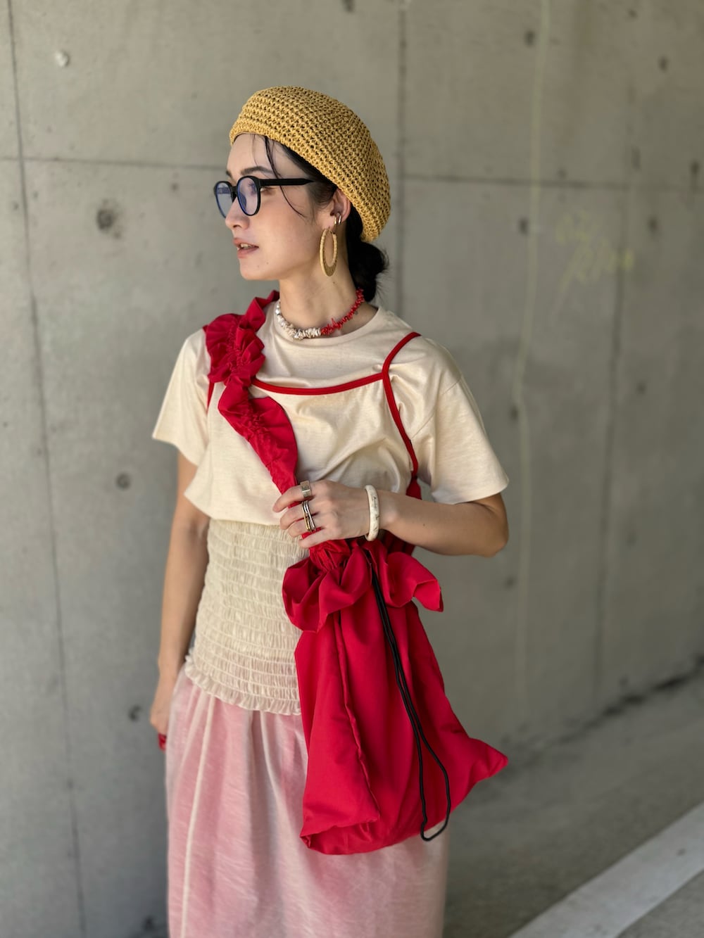 レッド系のショルダーバッグ、ベージュ系のTシャツ/カットソー、ベージュ系のスカートを着用したレディースの夏コーディネートの3枚目の写真