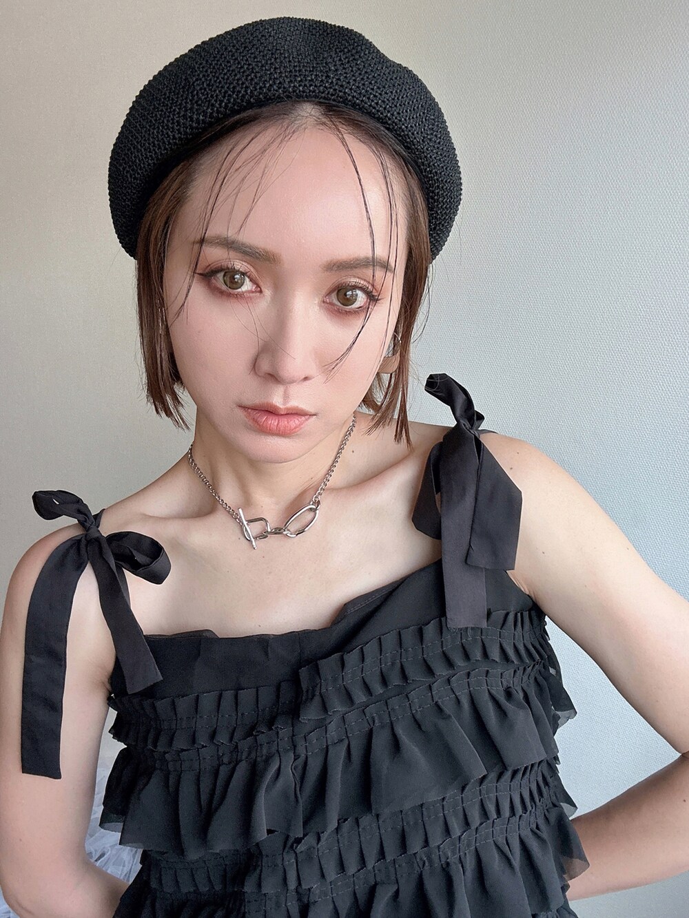 ブラック系のワンピース、ホワイト系のTシャツ/カットソー、ブルー系のデニムパンツを着用したレディースの春コーディネートの2枚目の写真