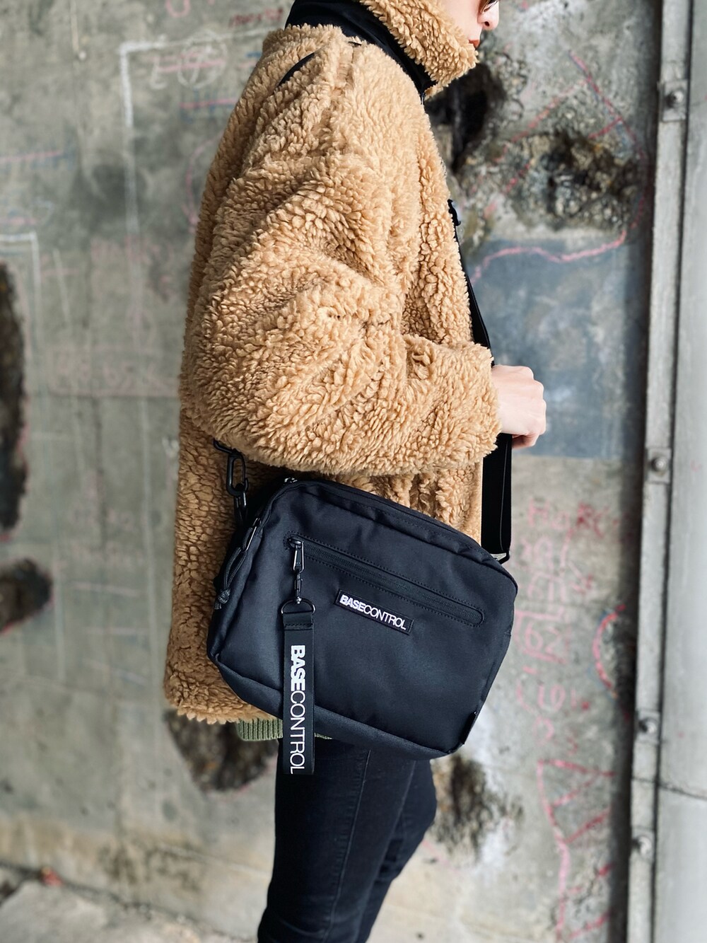 ベージュ系のブルゾン、ブラック系のショルダーバッグ、ブラック系のデニムパンツを着用したレディースの冬コーディネートの5枚目の写真