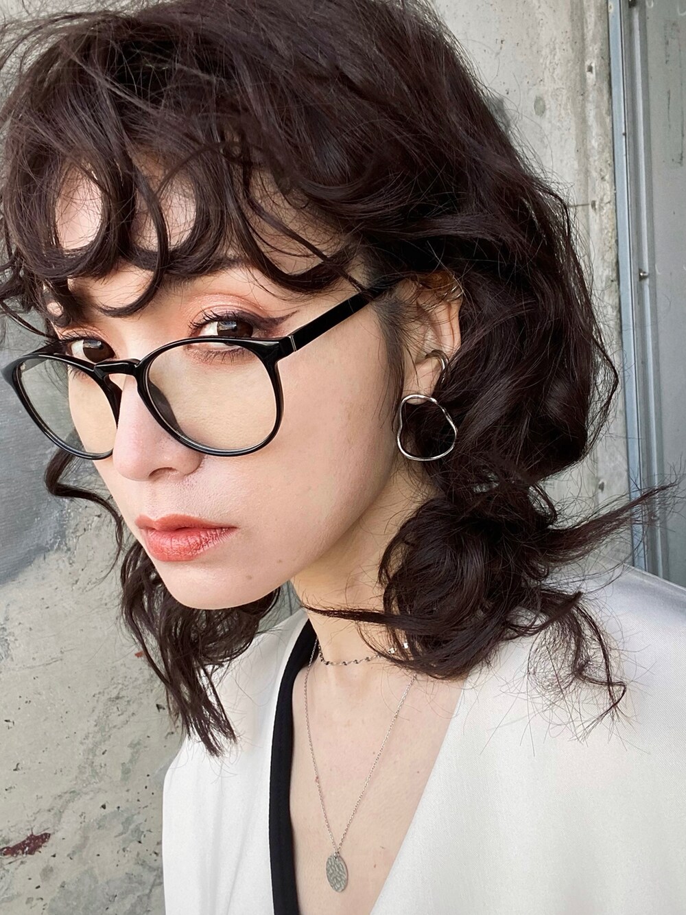 ブラック系のワンピース、グリーン系のハンドバッグ、ブラック系のローファーを着用したレディースの春コーディネートの4枚目の写真